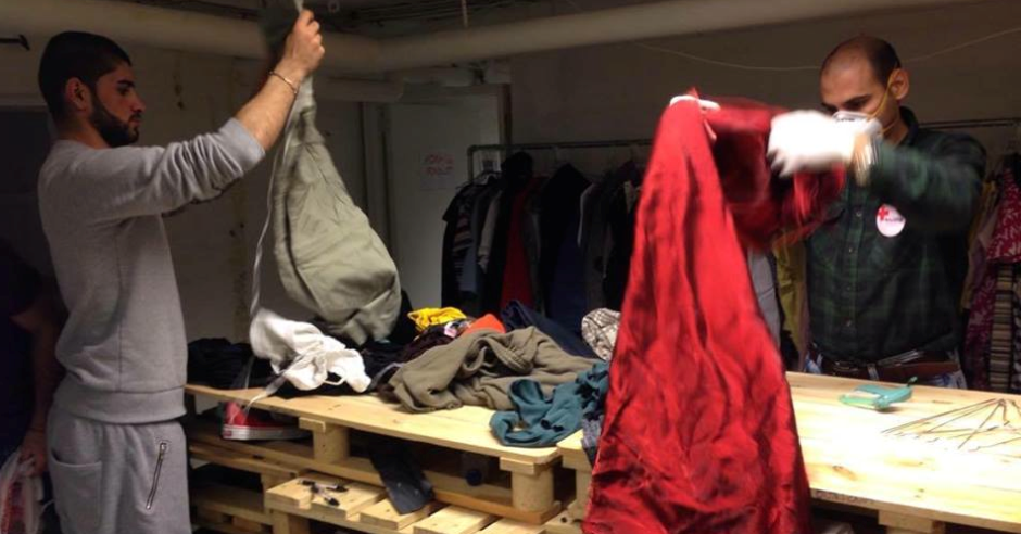 De to flygtninge Mohammed og Hussein har med stor interesse meldt sig som frivillige i Røde Kors’ pop-up butik på Vendersgade. Her sorterer de en masse doneret tøj.